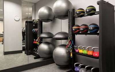 Fitness center featuring strength-training equipment, kettlebells, medicine balls, and functional fitness tools for a complete workout experience at Courtyard by Marriott Boston Brookline.