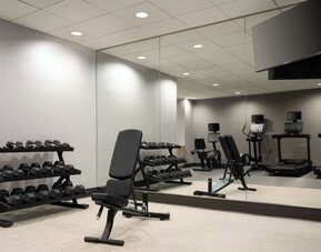 Well-equipped fitness facility with free weights, cardio machines, and mirrored workout spaces designed to support guests’ wellness routines at Courtyard by Marriott Boston Brookline.