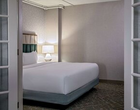 Private bedroom within a suite offering plush bedding, elegant furnishings, and a peaceful retreat for relaxation at DoubleTree by Hilton Westborough.