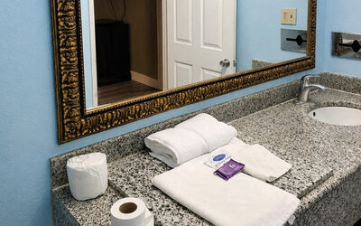 Guest bathroom vanity area featuring granite countertops, ample space, and essential amenities for a comfortable stay at Blue Way Inn & Suites Wichita East.