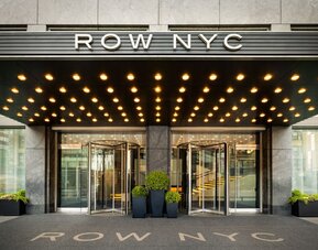 Close-up view of the iconic Row NYC entrance showcasing contemporary design, illuminated canopy lighting, and stylish curb appeal.