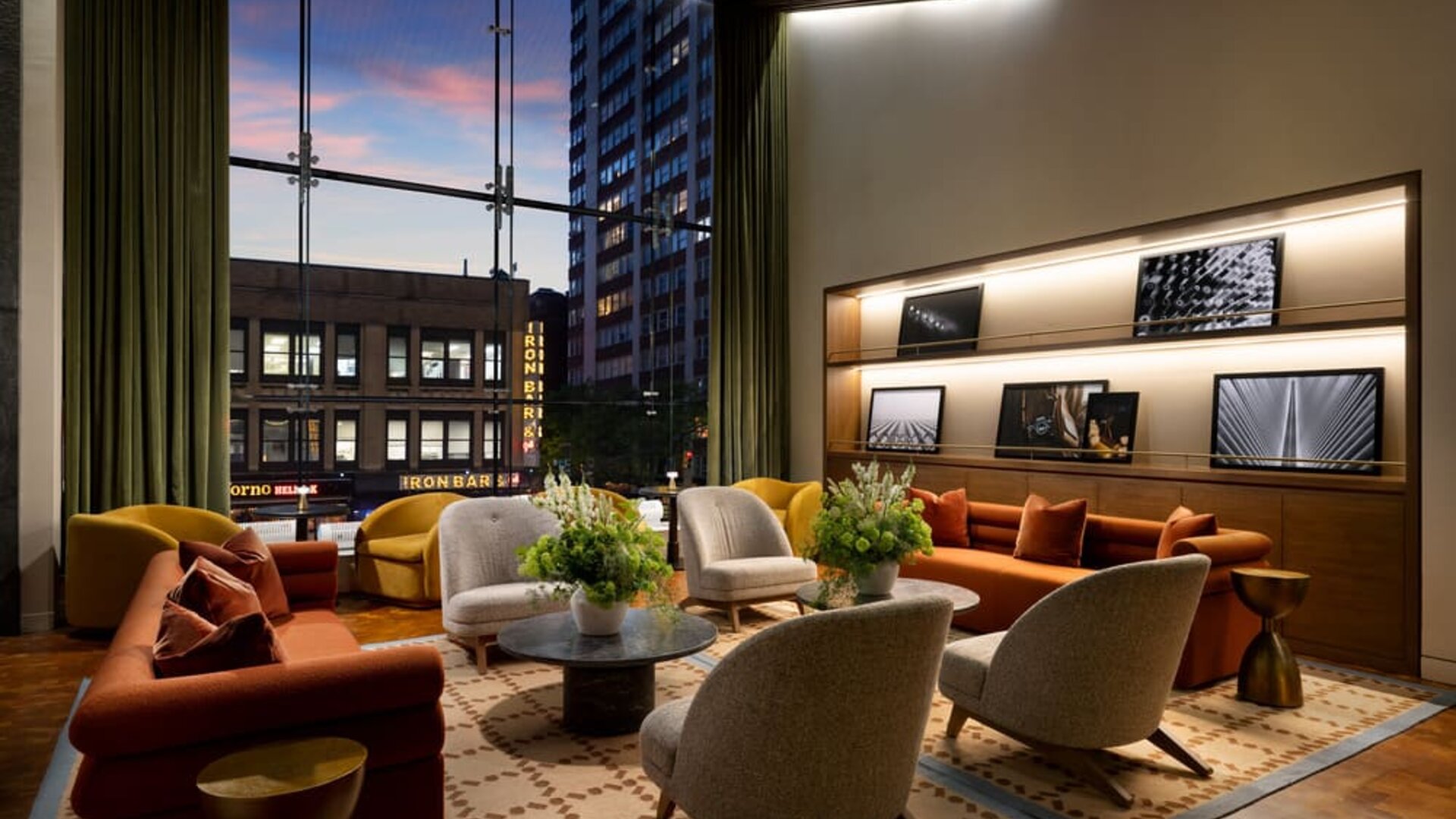 Sophisticated lobby lounge featuring floor-to-ceiling windows, contemporary furnishings, and comfortable gathering spaces at Row NYC.