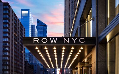 Entrance canopy of Row NYC illuminated with signature lighting, creating a memorable arrival experience in Times Square.