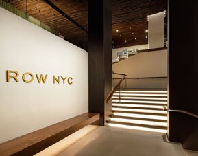 Grand staircase and lobby entrance featuring elegant lighting, contemporary architecture, and stylish design elements at Row NYC.