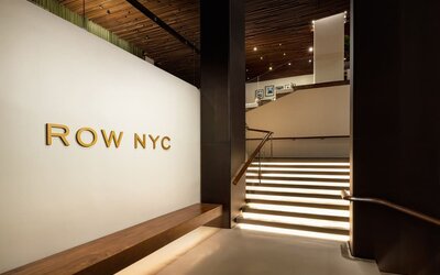 Grand staircase and lobby entrance featuring elegant lighting, contemporary architecture, and stylish design elements at Row NYC.