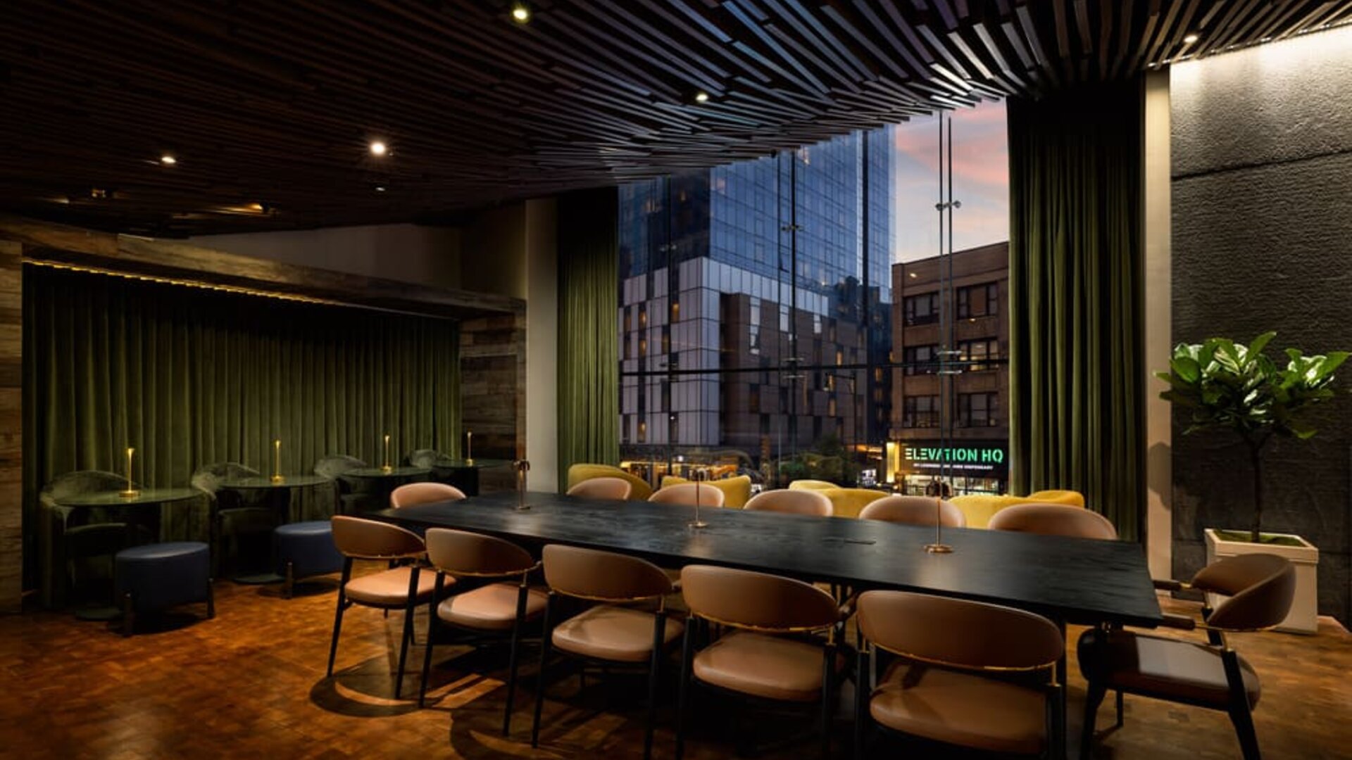 Stylish communal workspace and lounge area featuring large windows, contemporary furnishings, and flexible seating options at Row NYC.