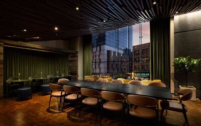 Stylish communal workspace and lounge area featuring large windows, contemporary furnishings, and flexible seating options at Row NYC.