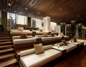 Tiered lounge seating area featuring modern furnishings, warm lighting, and inviting communal spaces for guests to relax and socialize at Row NYC.