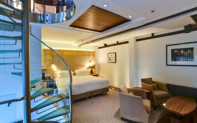 Day use room with sofa chairs and table at Hilton London Paddington.