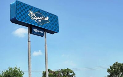 Hotel exterior and sign board at Signature Inn Houston Galleria.