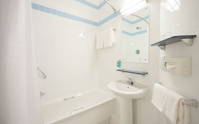 Guest bathroom with shower and tub at Leonardo Hotel Derby.