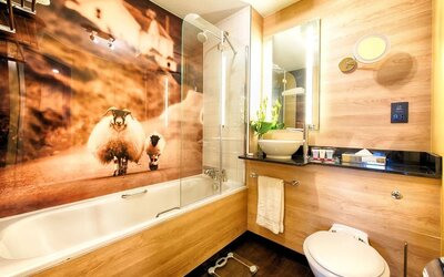 Guest bathroom with shower and tub at Leonardo Royal Hotel Edinburgh Haymarket. 