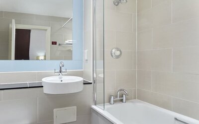 Guest bathroom with shower and tub at Leonardo Hotel Edinburgh City.