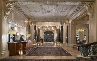Reception area with elegant architectural details and decorative chandeliers at The Grand Brighton. 