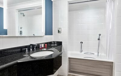 Guest bathroom with shower and tub at Leonardo Hotel Southampton Grand Harbour.