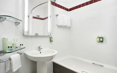 Guest bathroom with shower and tub at Leonardo Hotel Liverpool.