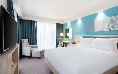 King bedroom with work desk, TV and sofa at the Hampton by Hilton London Docklands.