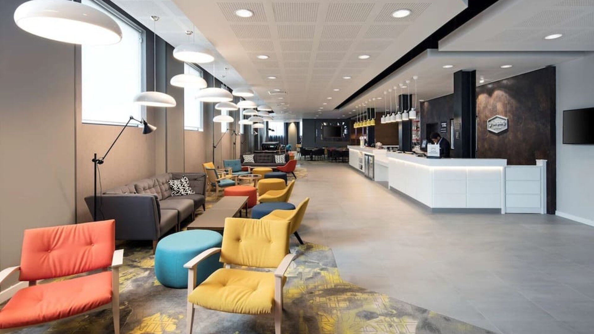 Spacious hotel lobby with lounge area, perfect for co-working at the Hampton by Hilton London Docklands.