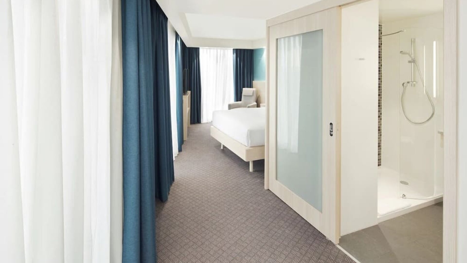 Bright day use room with TV, sofa and private bathroom at the Hampton by Hilton London Docklands.