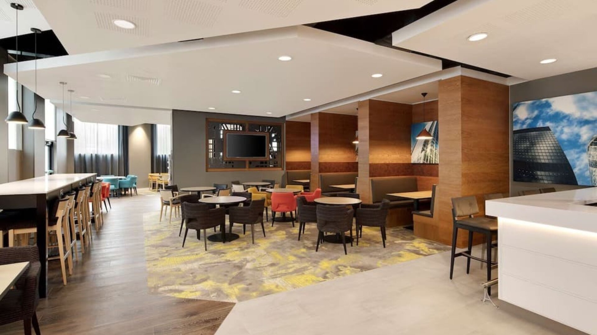 Lobby workspace with tables and chairs at the Hampton by Hilton London Docklands.