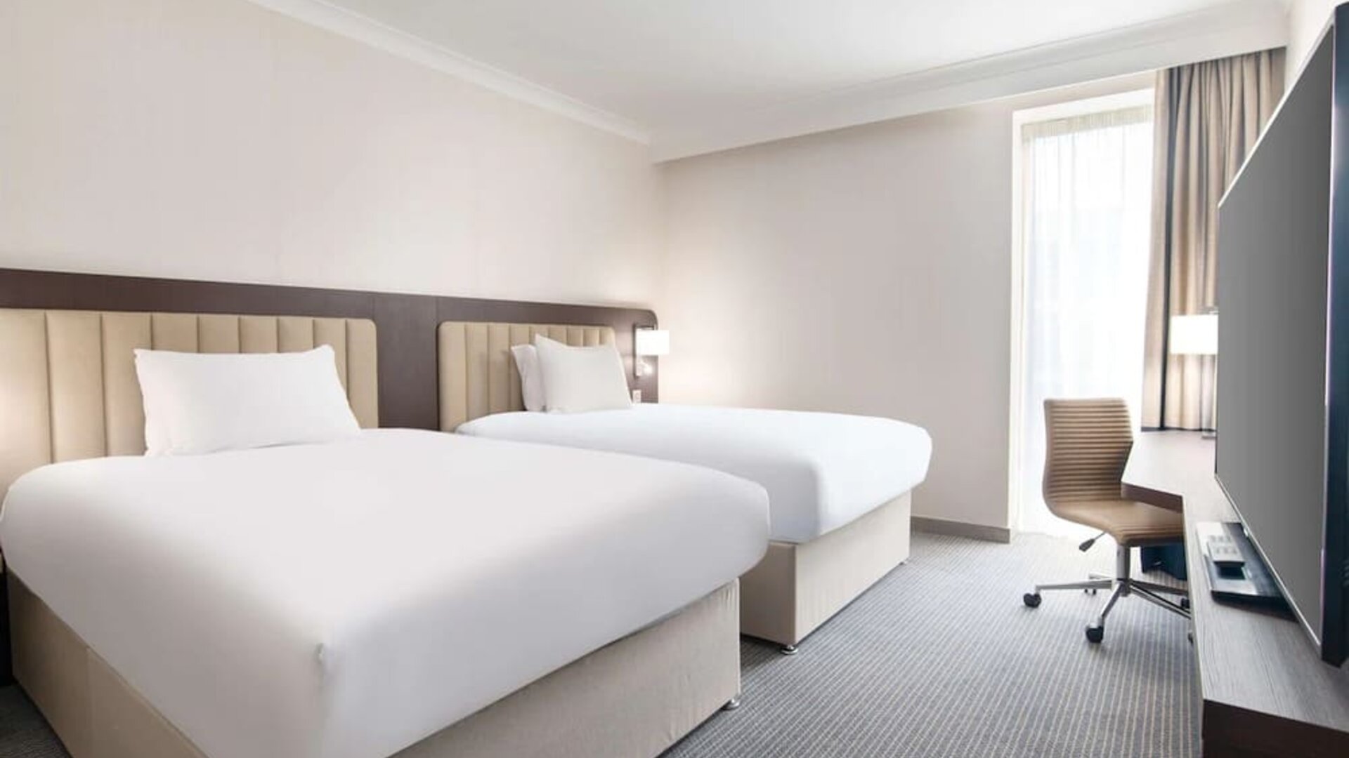 Double guest room with TV screen and desk at the Hilton London Gatwick Airport.