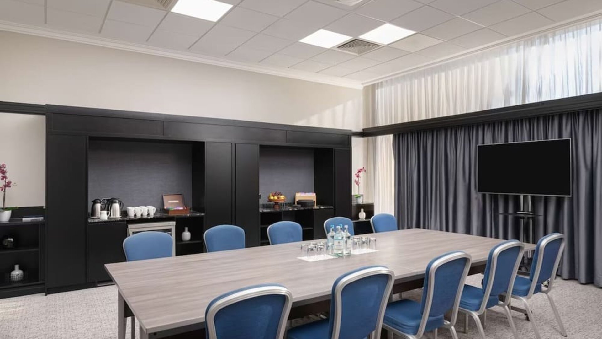 Elegant meeting room with TV for presentations at the Hilton London Gatwick Airport.
