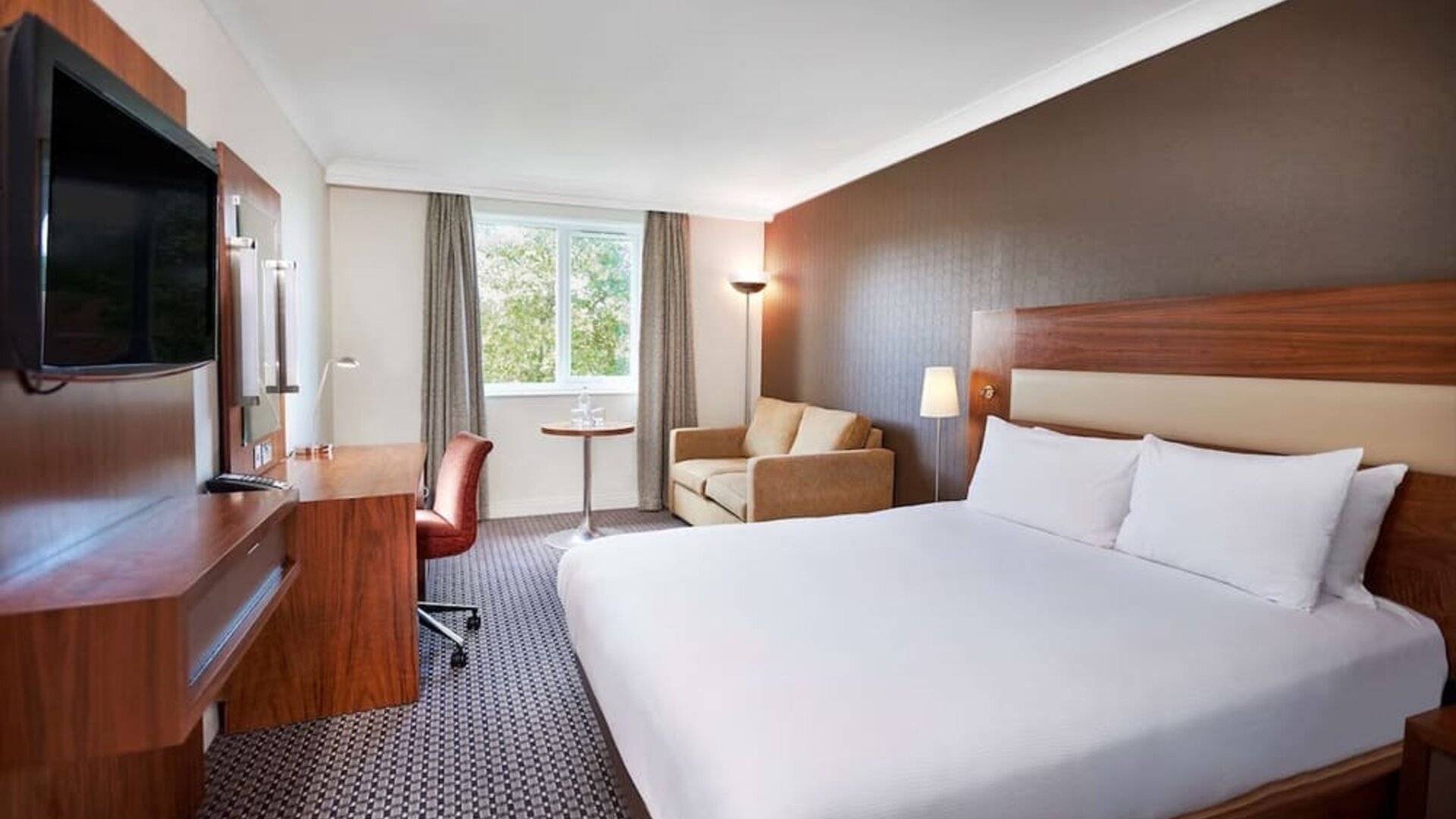 King suite with work desk, TV and lounge area at the DoubleTree by Hilton Bristol North.