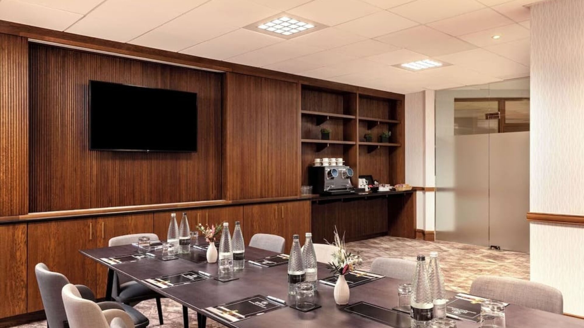 Professional meeting room with TV screen and coffee maker at the Hilton Birmingham Metropole.
