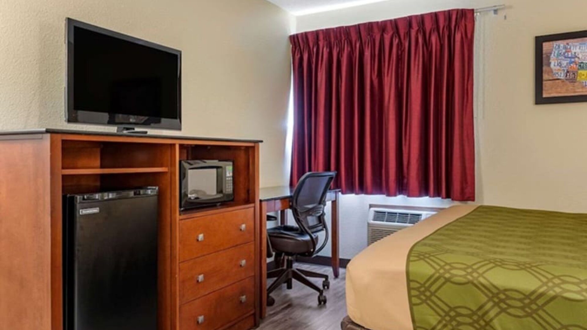 Day room with TV and fridge at Coratel Inn & Suites By Jasper River Falls.