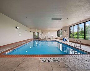 Spacious indoor pool offering a refreshing environment with ample natural light and comfortable seating for guests at Hampton Inn Ridgefield Park.
