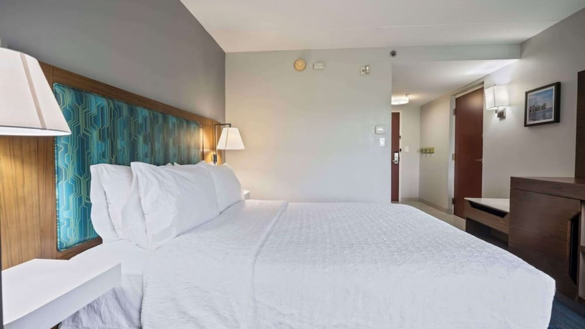 King guest room featuring a plush Hampton bed, modern furnishings, and a comfortable layout designed for both business and leisure travelers.
