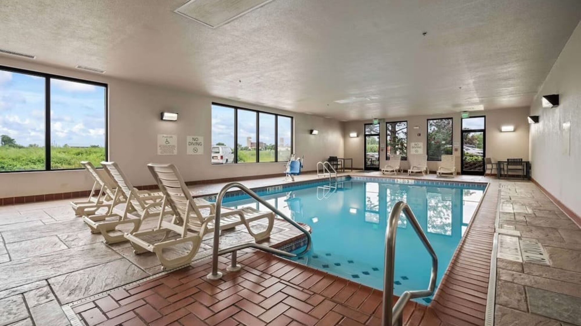 Spacious indoor pool offering a refreshing environment with ample natural light and comfortable seating for guests at Hampton Inn Ridgefield Park.