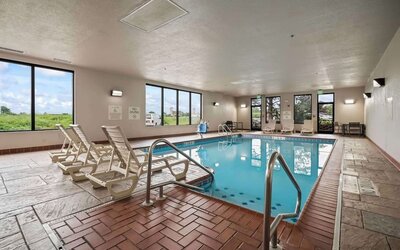 Spacious indoor pool offering a refreshing environment with ample natural light and comfortable seating for guests at Hampton Inn Ridgefield Park.
