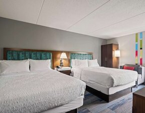 Double Queen guest room featuring two plush beds, modern décor, spacious accommodations, and comfortable amenities for families and groups.