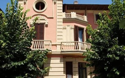 Exterior view of Petit Chateau highlighting its historic villa design surrounded by mature trees and gardens.