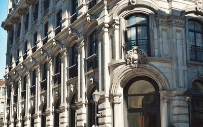 Historic stone façade with ornate architectural details, arched entrance, and large windows in daylight. Hotel Gault.