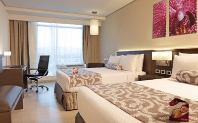 Bright and spacious double guest room featuring two beds, work-friendly amenities, and contemporary furnishings at Crowne Plaza Panama Airport.