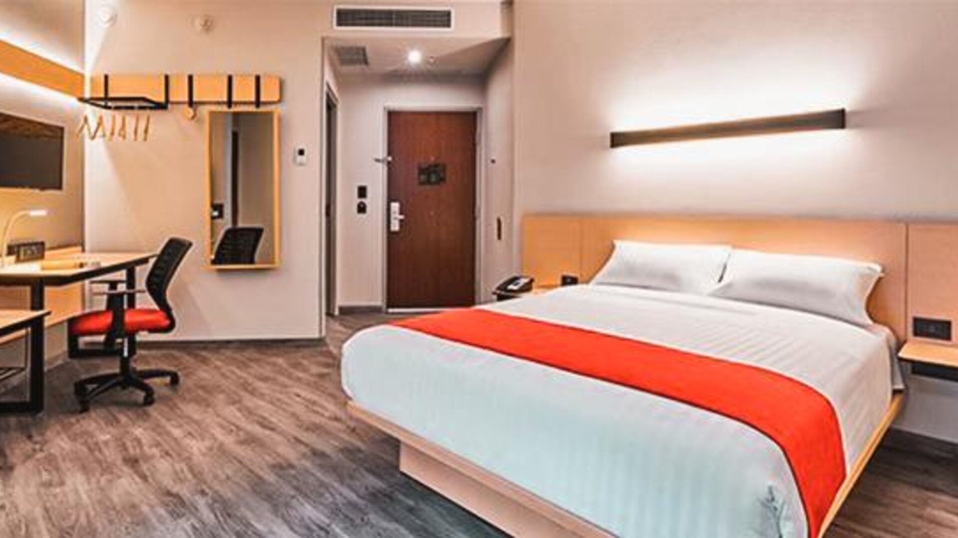 Spacious guest room with a king-size bed, workspace, and modern amenities designed for both business and leisure stays.