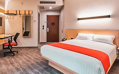 Spacious guest room with a king-size bed, workspace, and modern amenities designed for both business and leisure stays.
