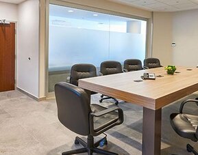 Private meeting room with conference table seating, suitable for business meetings, presentations, and small corporate events.