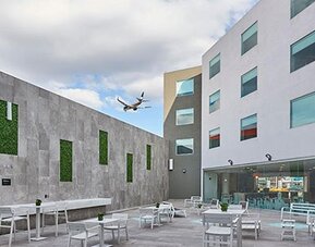 Outdoor courtyard patio with seating areas and open-air space, providing a relaxing environment near the hotel.