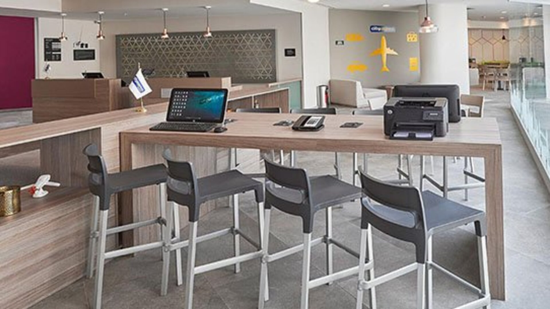 Business workspace with shared high-top tables, computer access, and convenient facilities for business travelers.