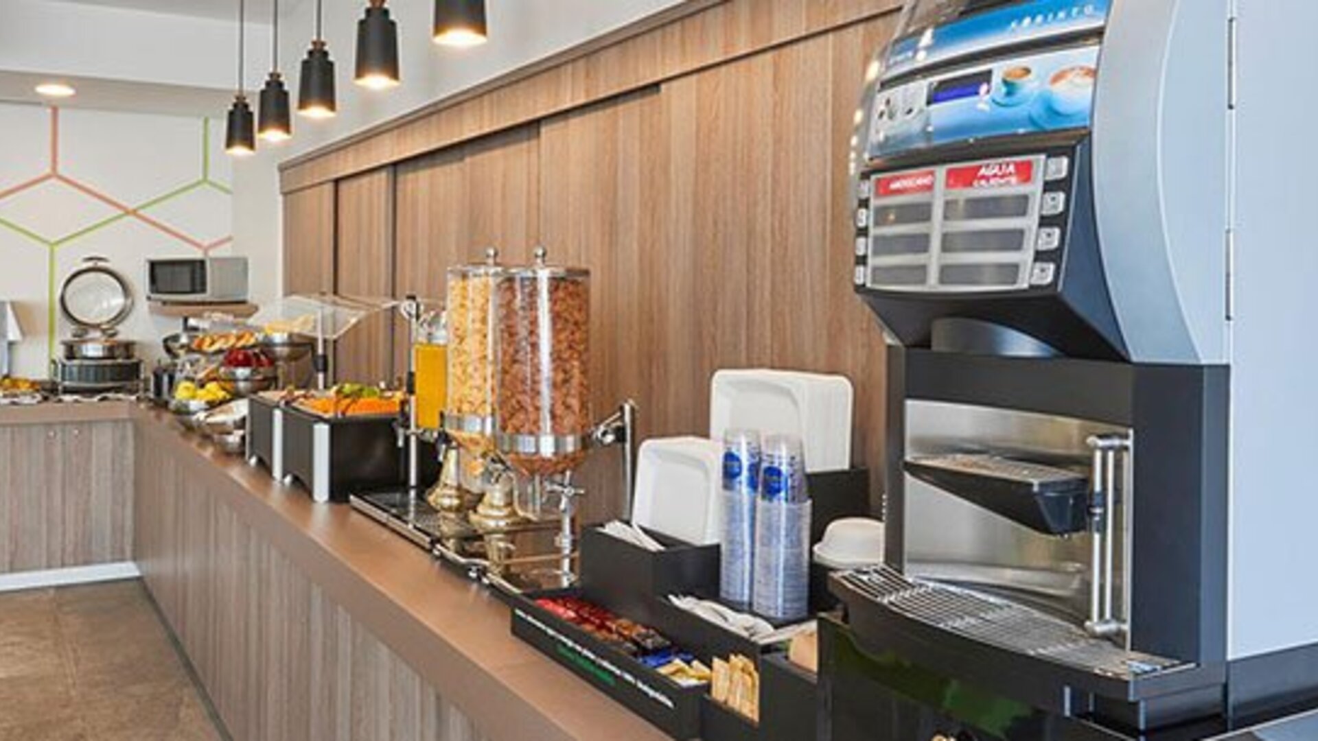 Complimentary breakfast station featuring hot beverages, juices, cereals, and a selection of morning dining options.