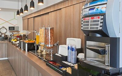 Complimentary breakfast station featuring hot beverages, juices, cereals, and a selection of morning dining options.