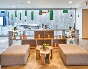 Spacious communal seating area overlooking the hotel's central atrium, offering a bright and inviting atmosphere.
