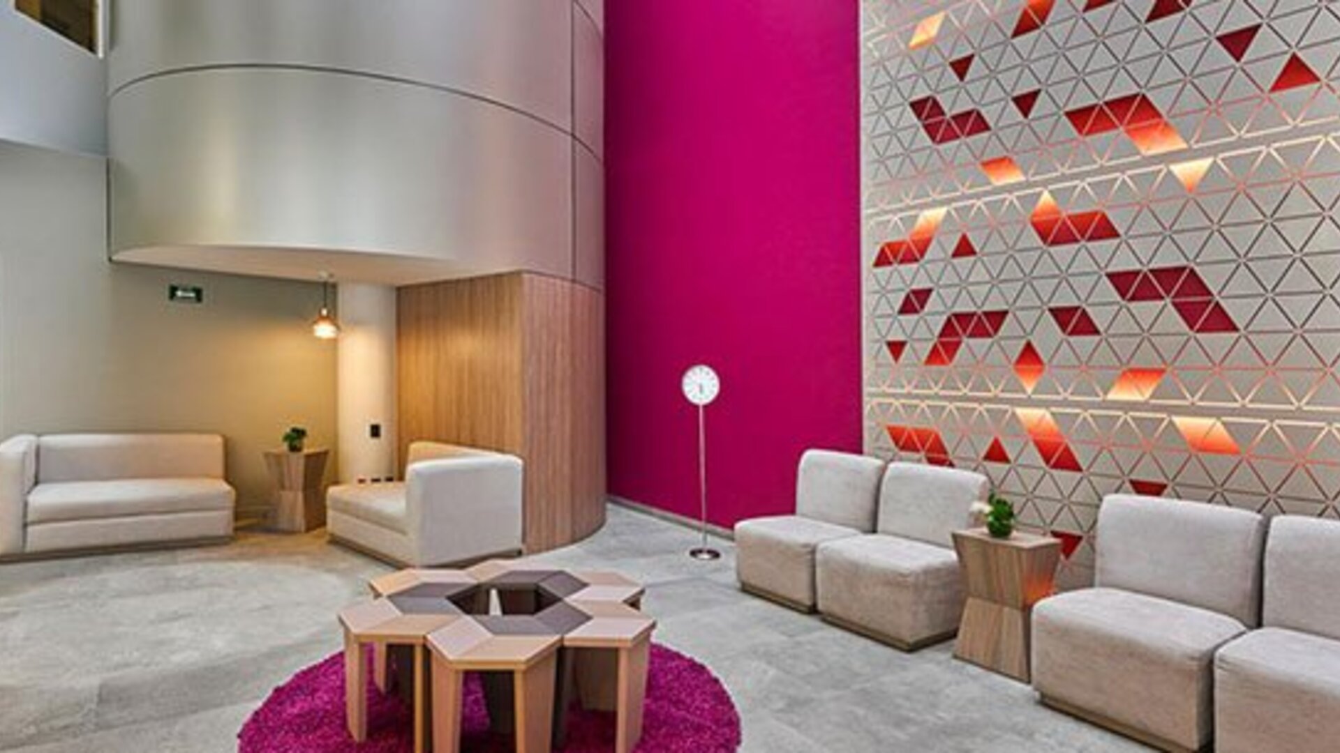 Stylish hotel lobby featuring contemporary seating, vibrant accent walls, and a comfortable space for guests to relax or meet.