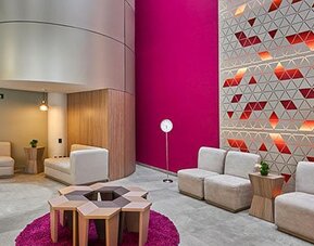 Stylish hotel lobby featuring contemporary seating, vibrant accent walls, and a comfortable space for guests to relax or meet.