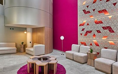 Stylish hotel lobby featuring contemporary seating, vibrant accent walls, and a comfortable space for guests to relax or meet.