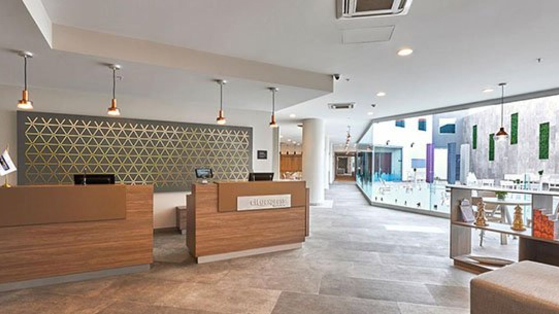Bright and modern reception area with streamlined check-in counters and open-plan design welcoming guests to City Express by Marriott Aeropuerto Ciudad de México.