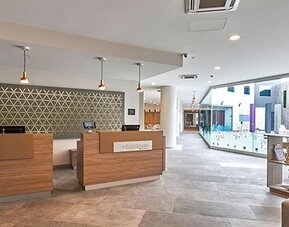 Bright and modern reception area with streamlined check-in counters and open-plan design welcoming guests to City Express by Marriott Aeropuerto Ciudad de México.